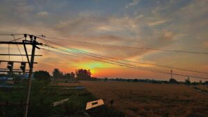 Golden sunrise above village fields, morning light in beautiful landscape photography
