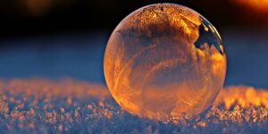 Close-up of frozen bubble with icy patterns in soft light showing best nature photography