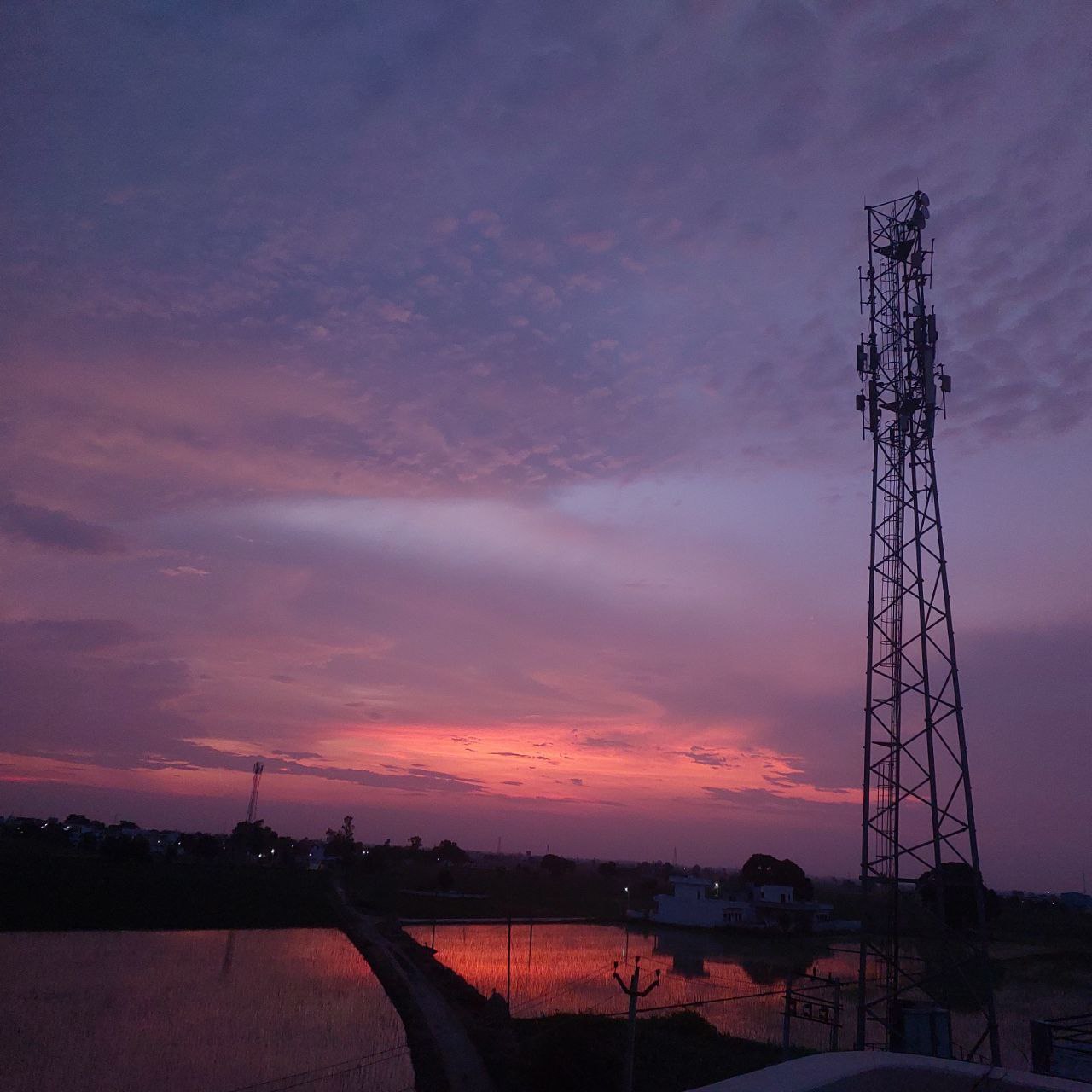 Stunning pink and violet dusk sky behind a silhouette of a tall communication tower, peaceful twilight landscape for Golden Landscapes gallery