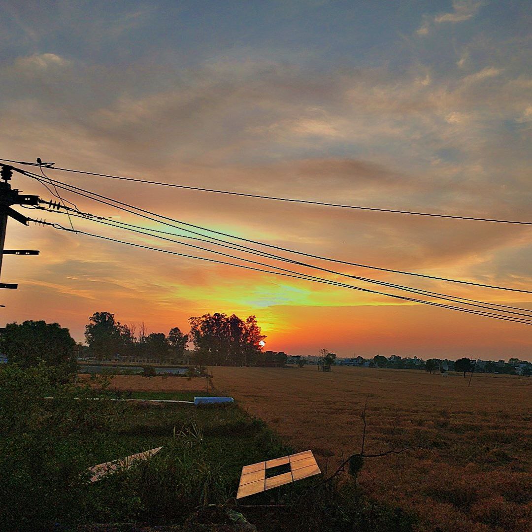 Gentle sunrise with soft orange and pink tones lighting up the countryside, serene morning field view for Golden Landscapes gallery